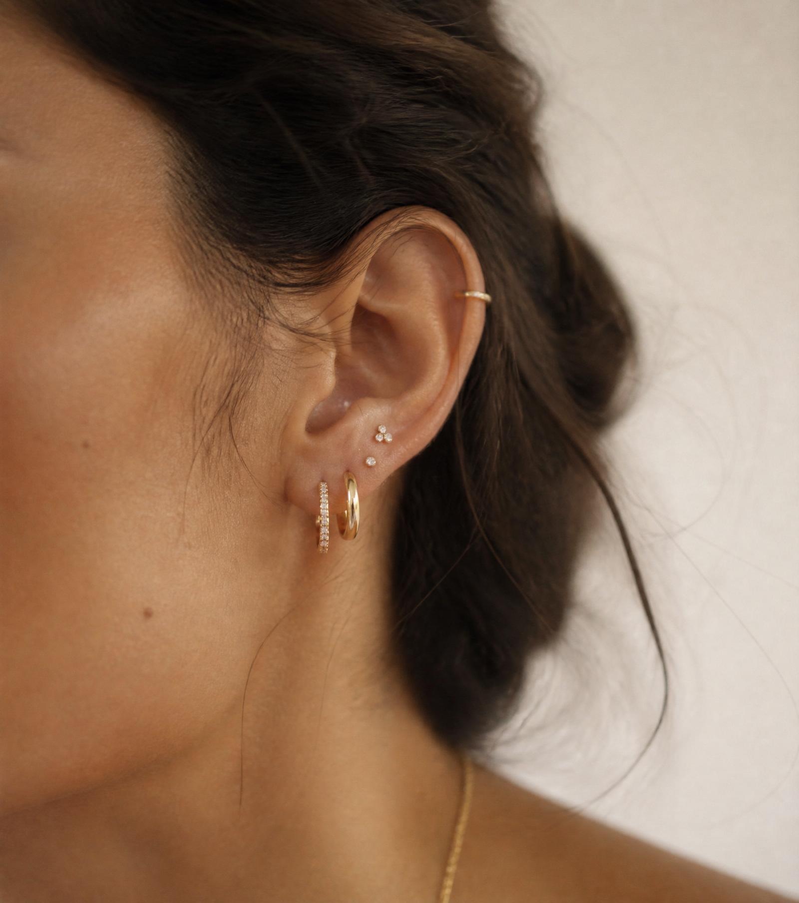 Detalle de oreja con piercings curados